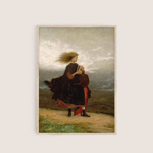 A fine art print hangs on a neutral wall in a simple wooden picture frame. The picture depicts a windswept young lady walking across a landscape in a velvet coat and holding a book.