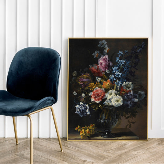 Floral painting on a wall next to a dark blue chair with gold legs.