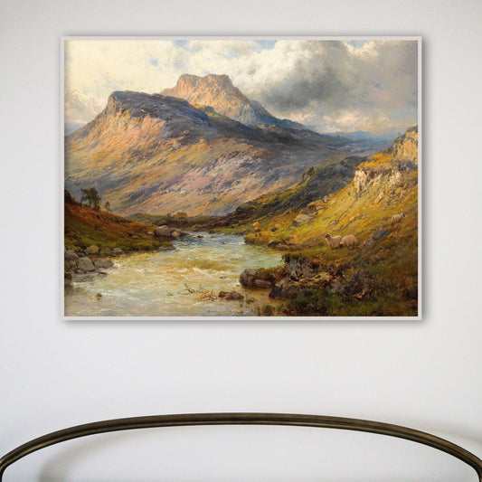 A fine art print of a Scottish landscape in a white frame on a white wall.