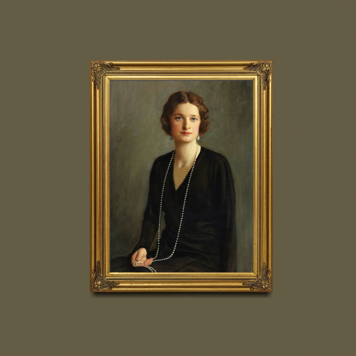 A fine art print of a beautiful portrait from the Art Deco period. The print is displayed hanging on a wall in an ornate gold picture frame.