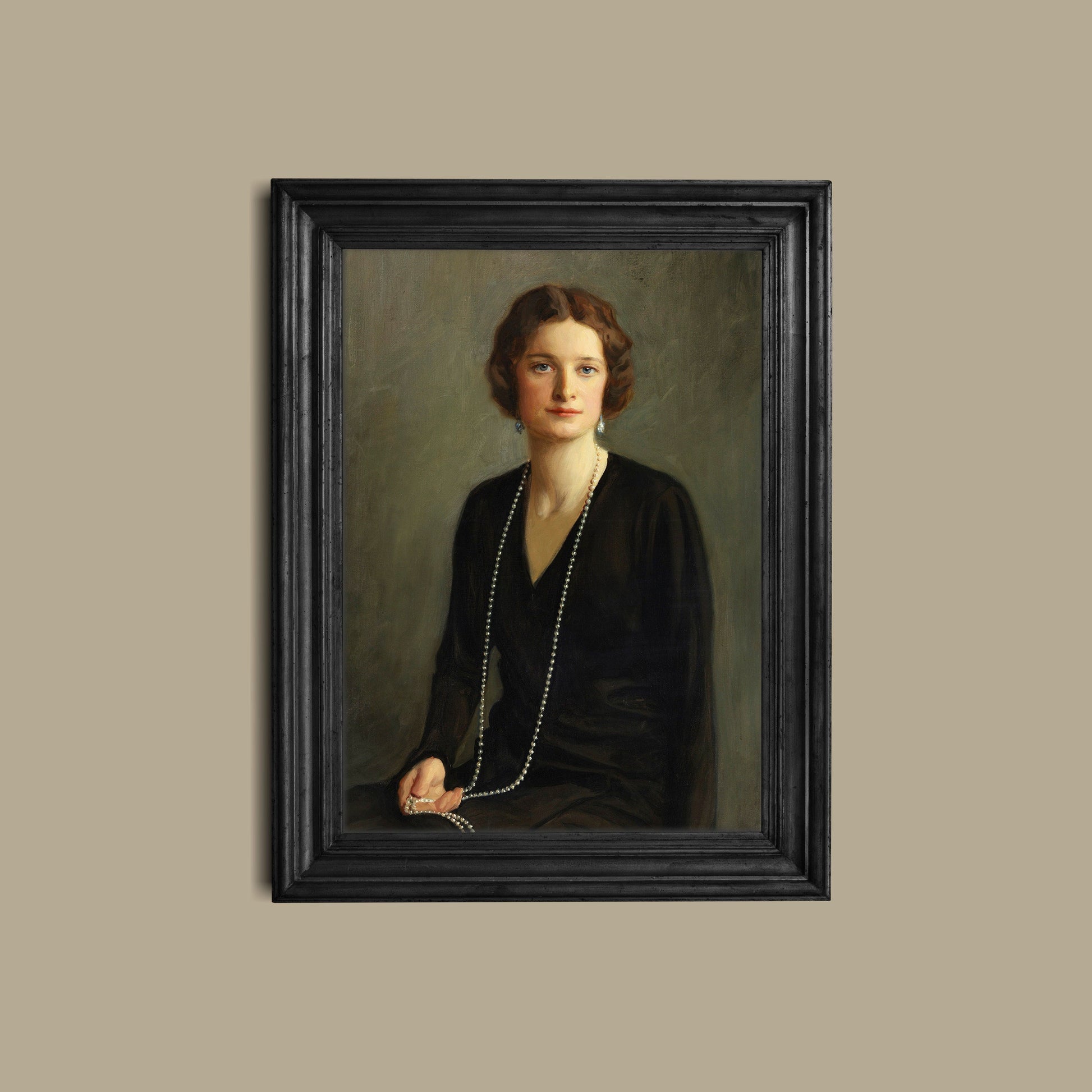 A fine art print of a beautiful portrait from the Art Deco period. The print is displayed hanging on a wall in a black picture frame.