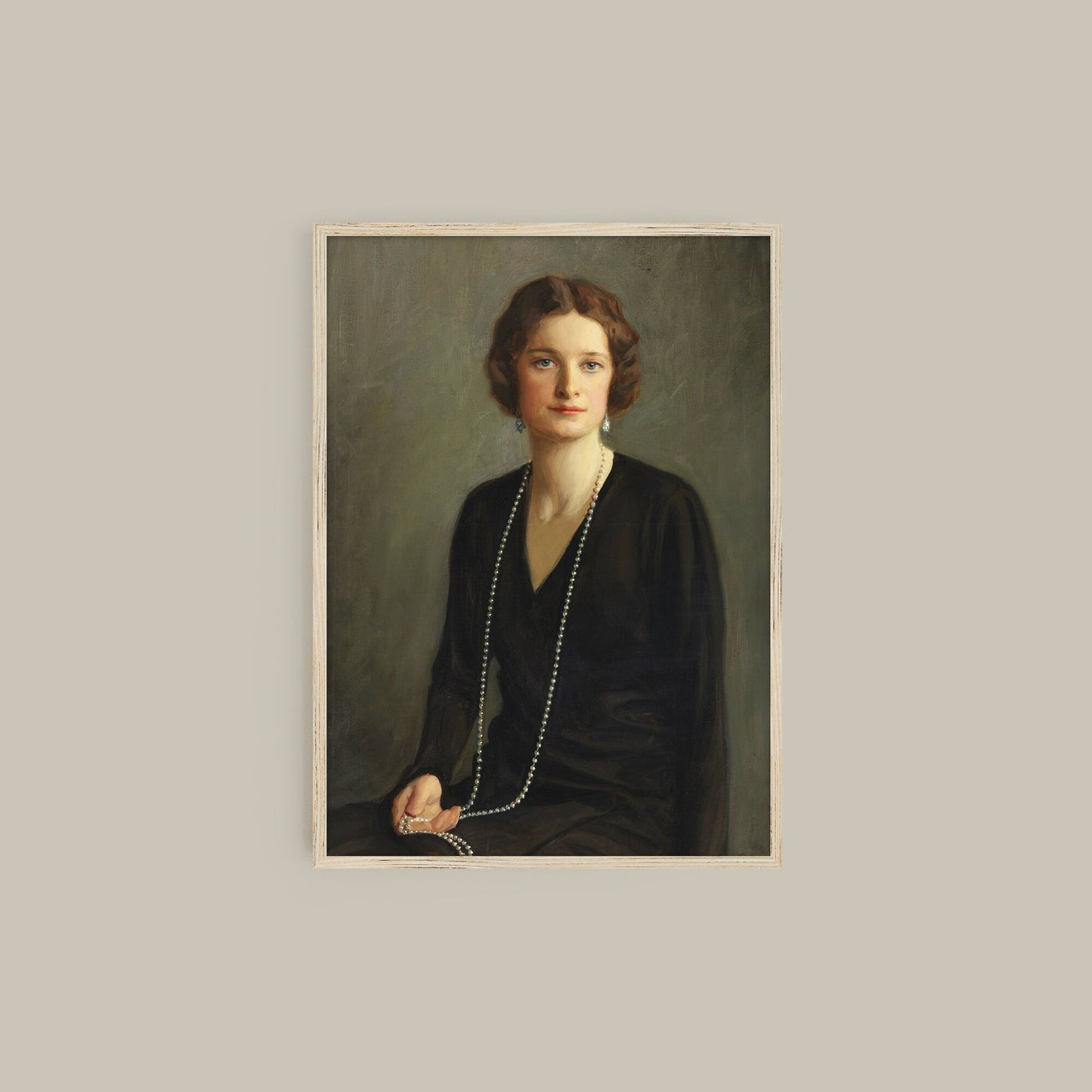 A fine art print of a beautiful portrait from the Art Deco period. The print is displayed hanging on a wall in a thin wooden picture frame.