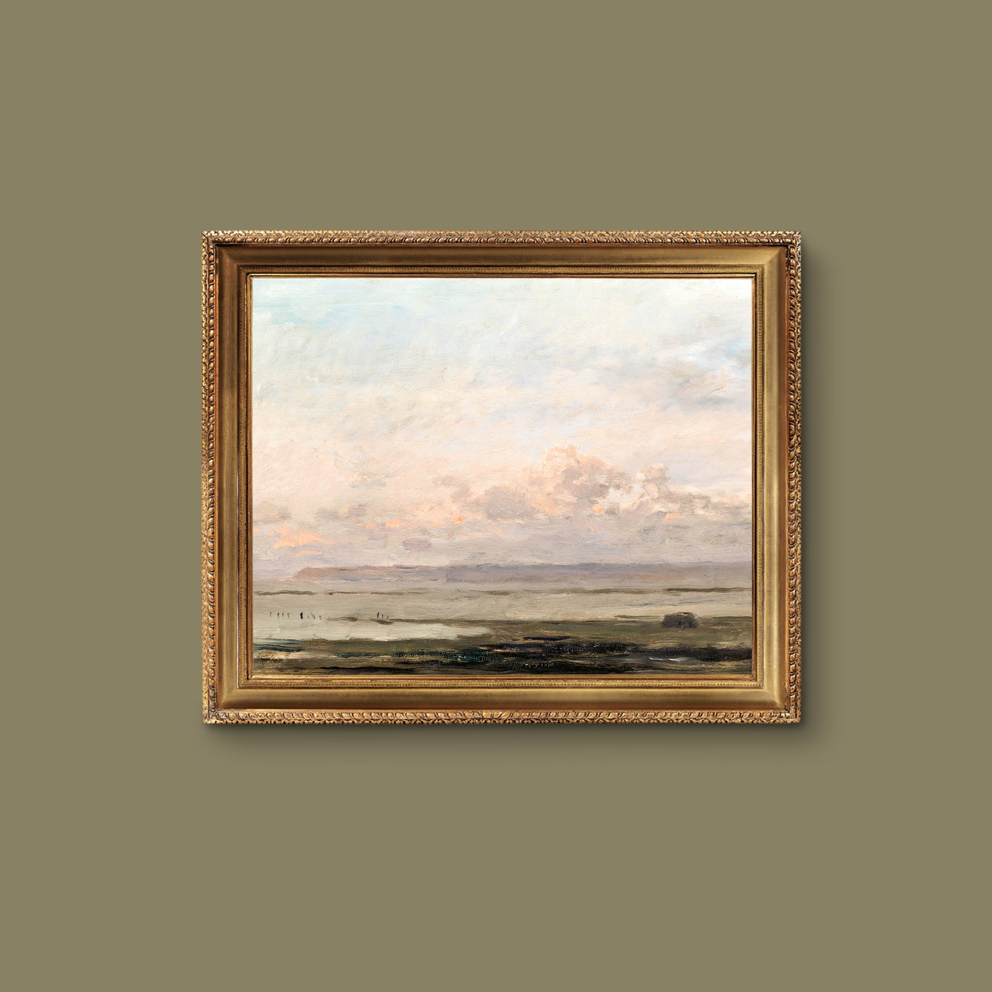 Framed print of a beach landscape on a gold frame on a green wall