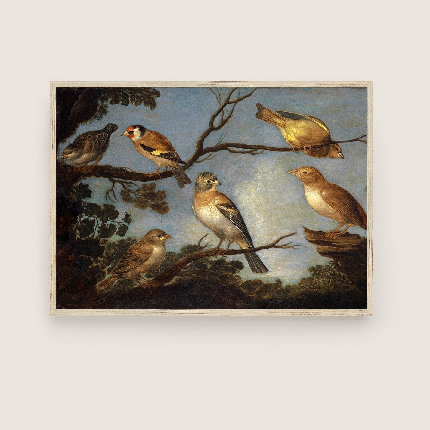 A framed print of garden birds gathered together on the branches of a tree. The print is displayed hanging on the wall in a thin light-wood picture frame.