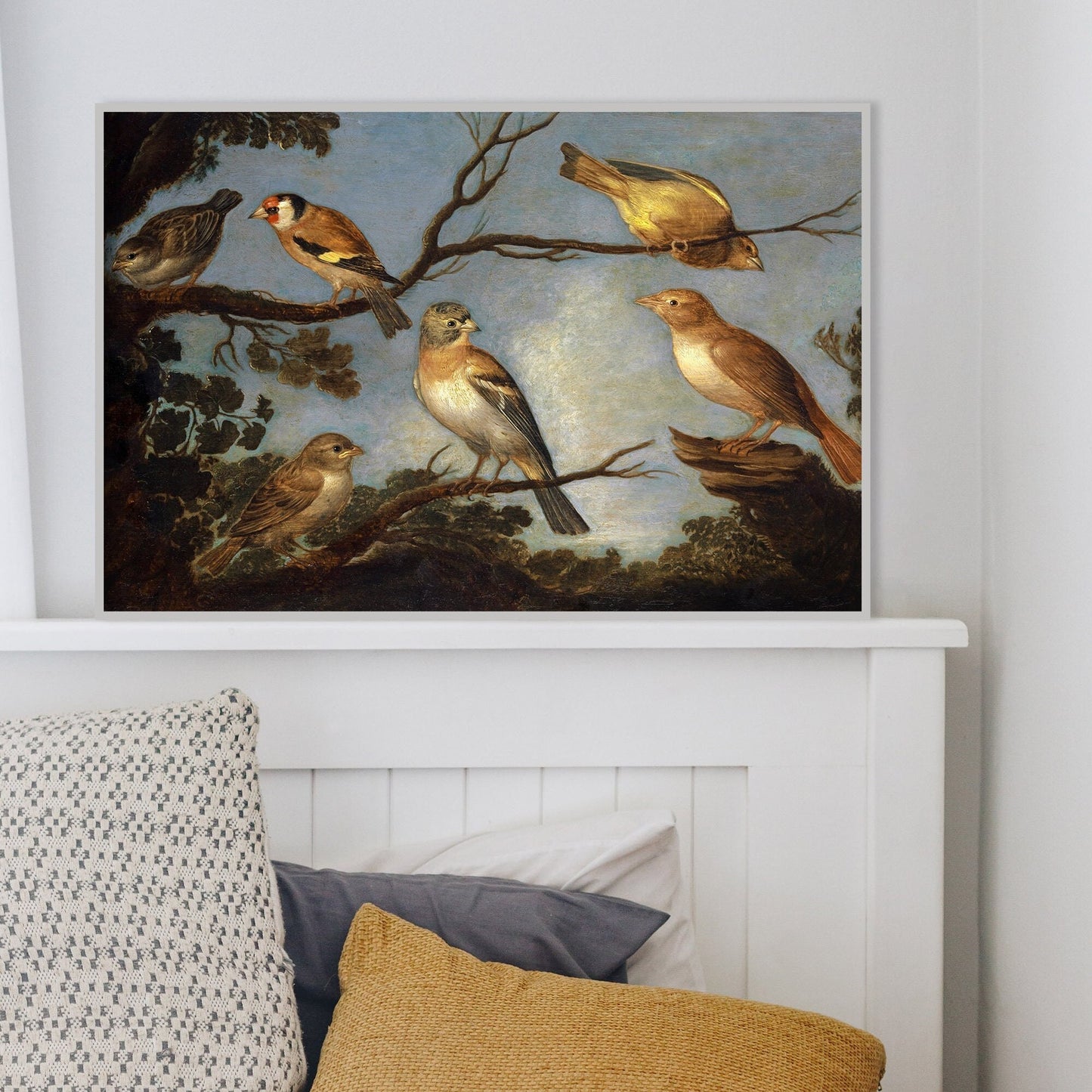 A framed print of garden birds gathered together on the branches of a tree. The colours of their feathers stand out against the blue sky behind them. The print is displayed in a white picture frame.