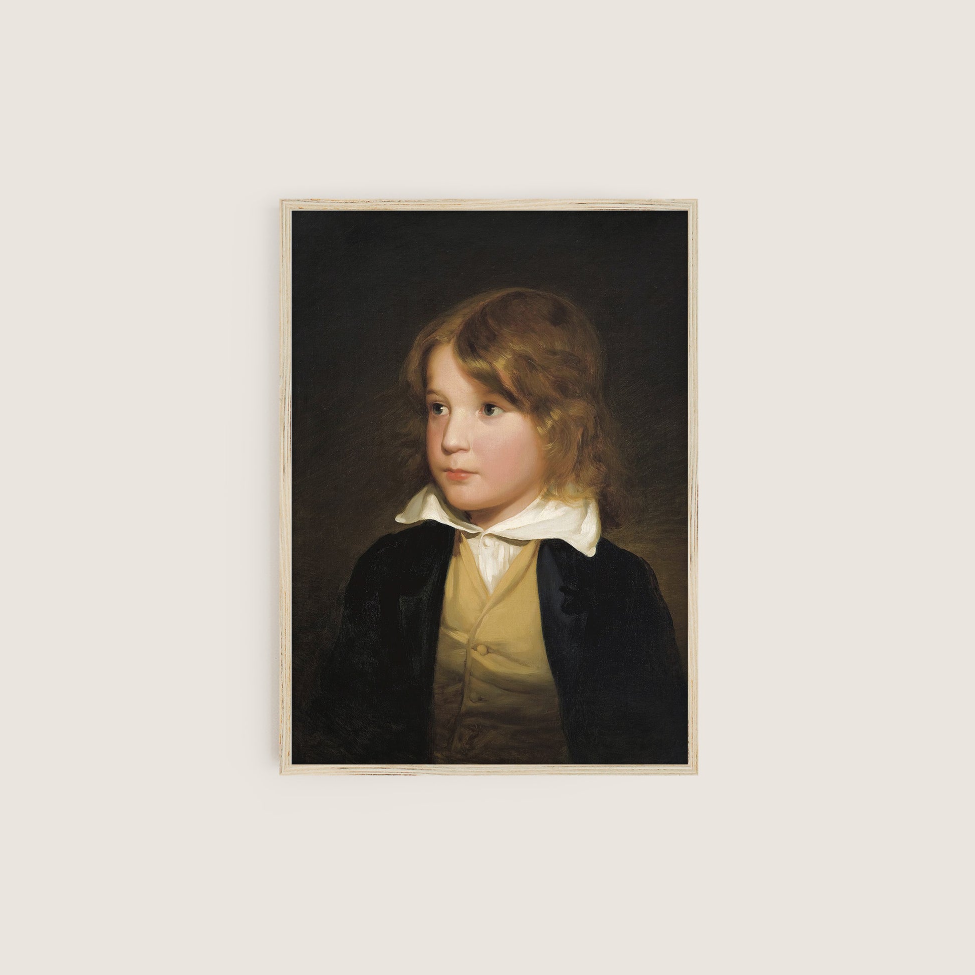 Framed portrait of a young boy on a dark background hung on a light beige wall