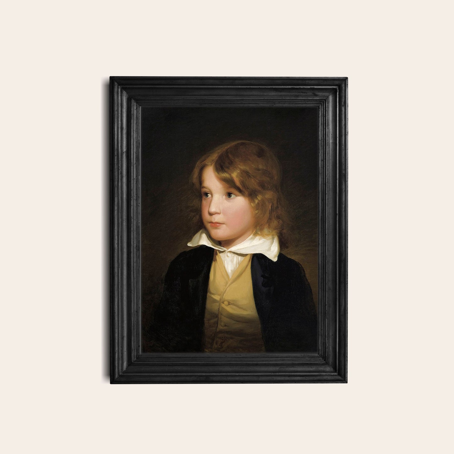 Framed portrait of a young boy in a black frame on a light background