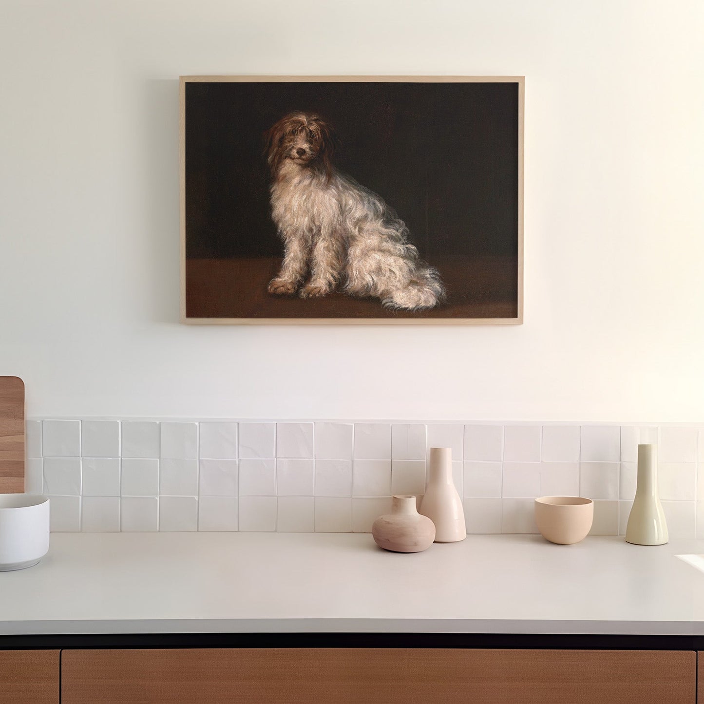 Framed artwork of a dog on a dark background hanging in a kitchen above a counter top.