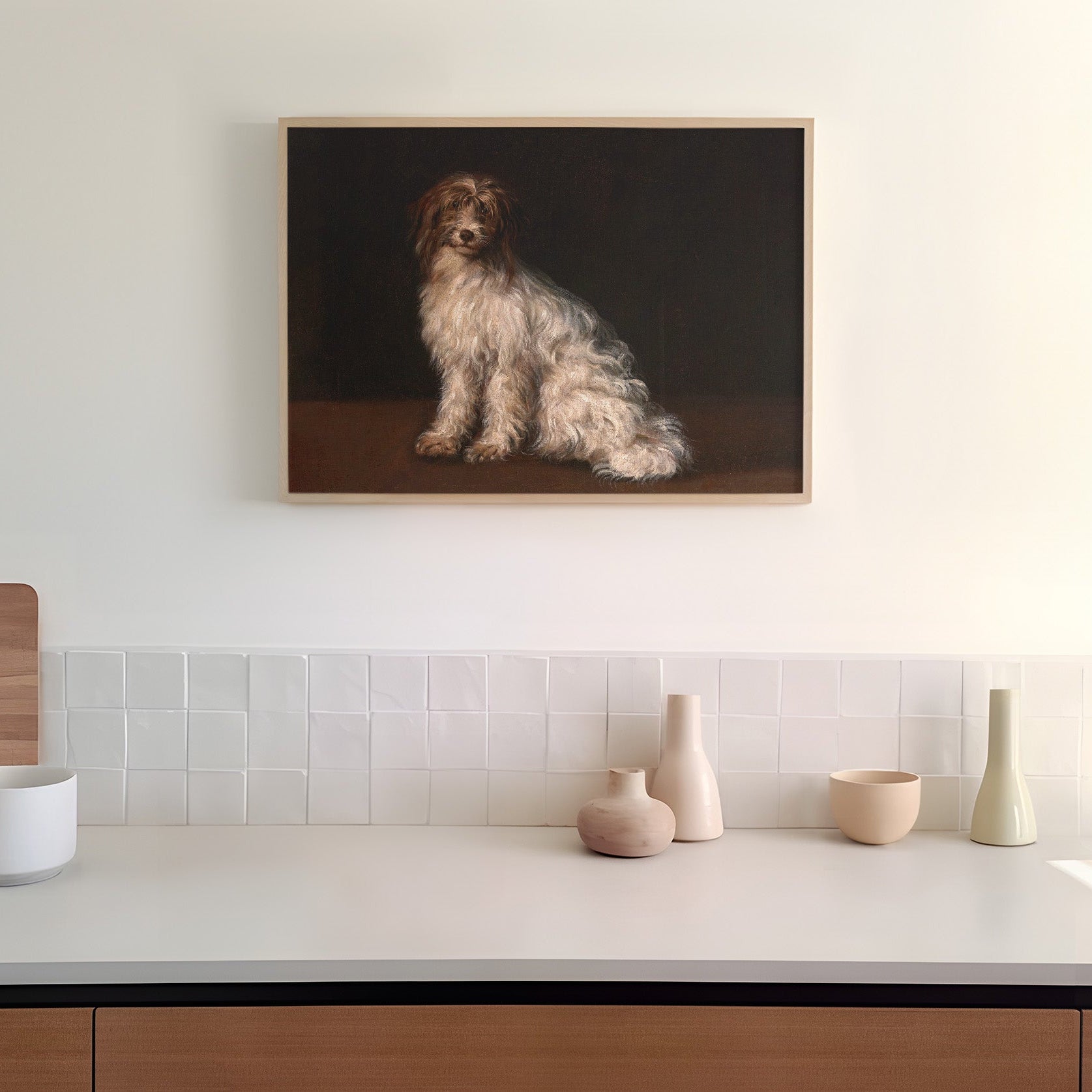 Framed artwork of a dog on a dark background hanging in a kitchen above a counter top.