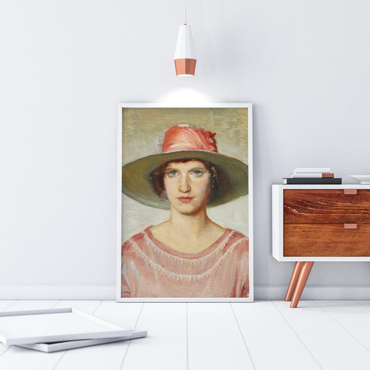 A fine art print of an Art Deco oil painting of a portrait of a lady. The print is displayed in a thin white frame resting on the floor next to a side table.