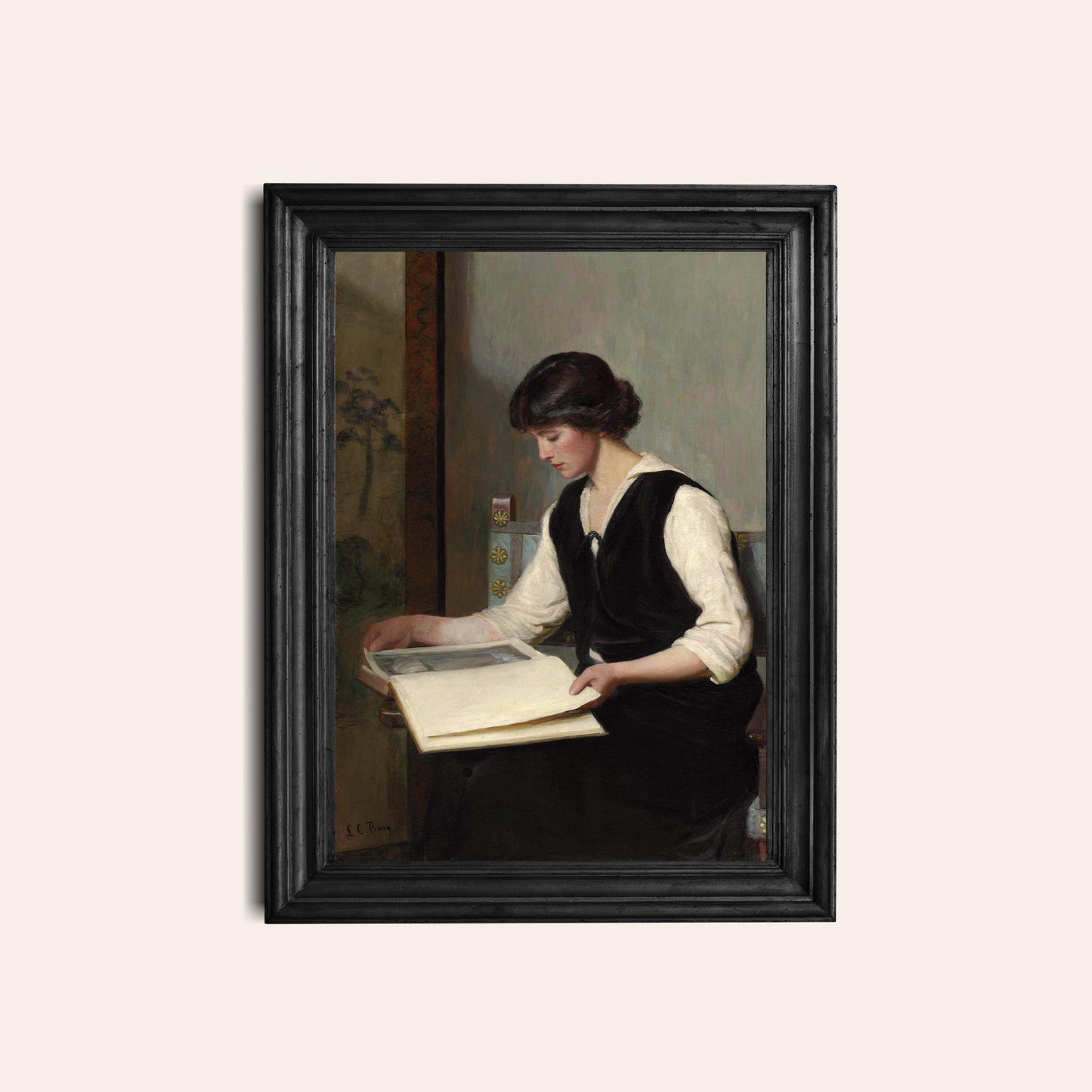 Framed print of a woman reading a book on a light beige background