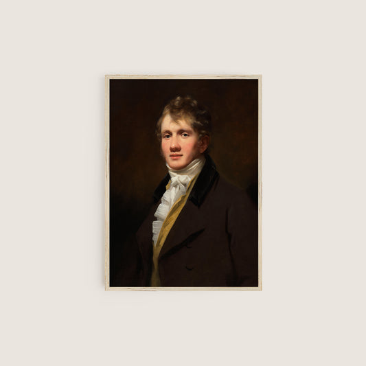 Framed portrait print of a man in formal attire in a wooden frame on a white wall.