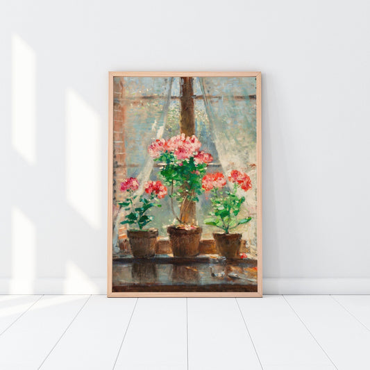 Framed print of potted plants, resting against a white wall in a wooden picture frame.