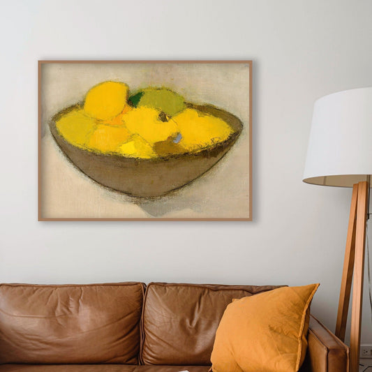 Framed print of a bowl of yellow lemons on a wall above a brown leather sofa.