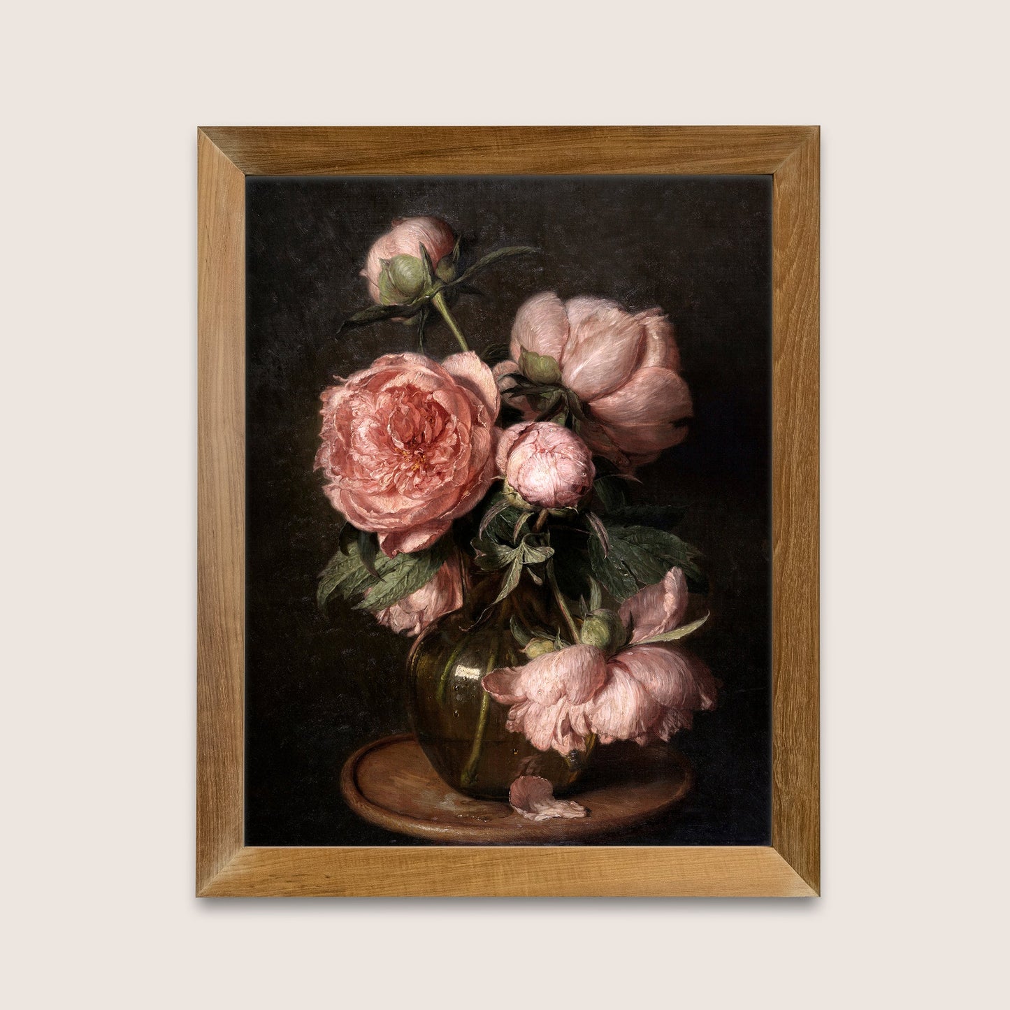 Framed art print of pink peonies on a dark background, hung on a white wall.