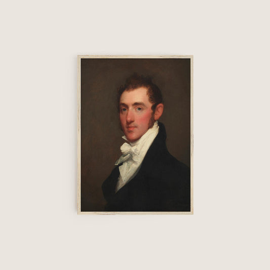 A fine art print of a Regency-era gentleman. The print is displayed in a simple wooden picture frame on a white wall.