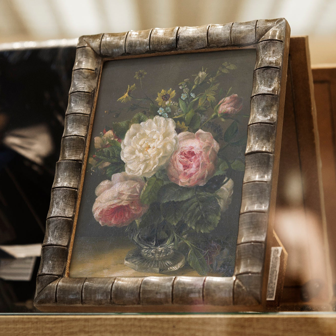Floral print in a decorative frame on a wooden surface
