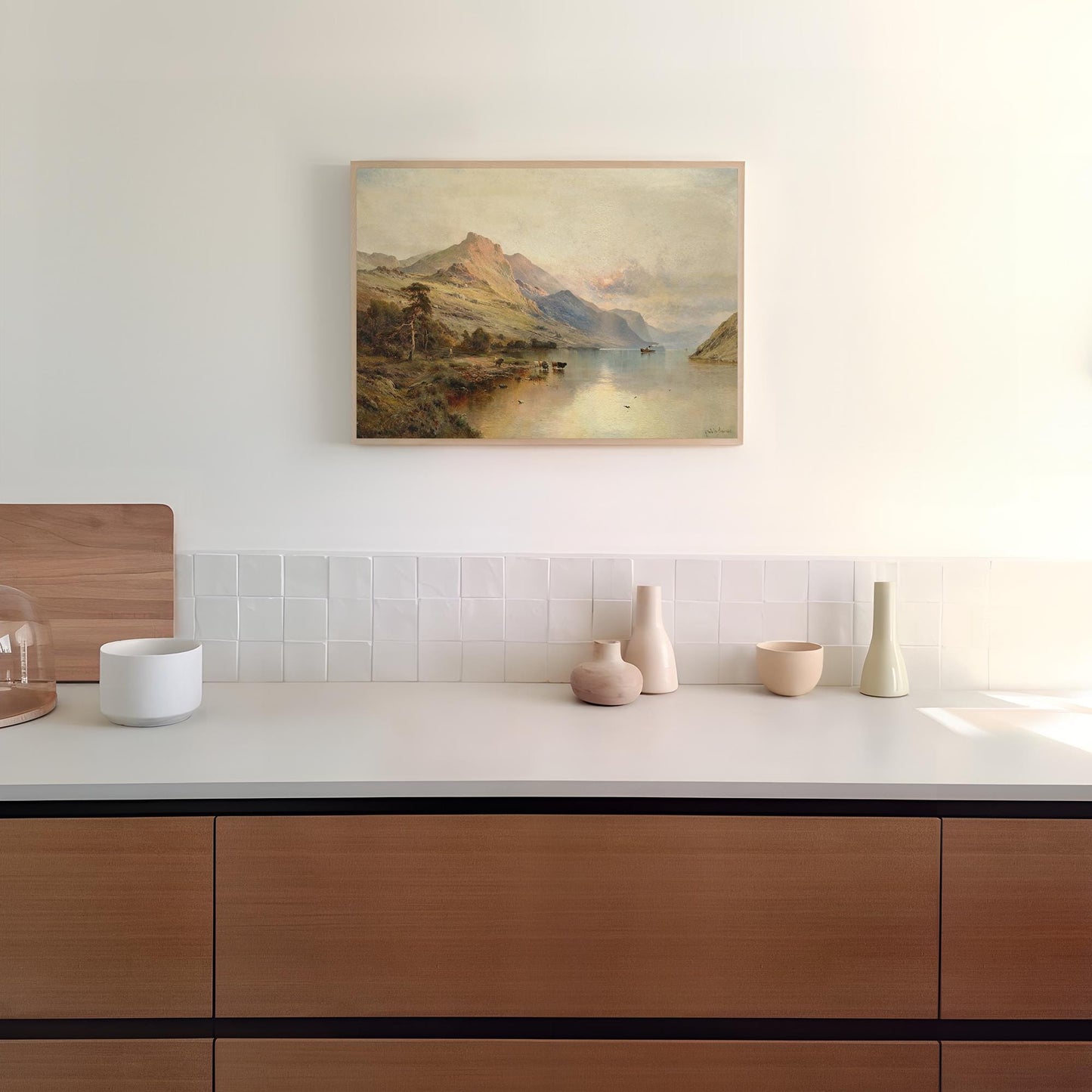 Modern kitchen with wooden cabinets, white countertop, and a landscape print on the wall.
