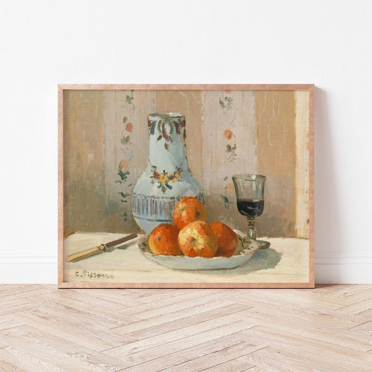 Framed still life print with a vase, apples, and a glass on a table.
