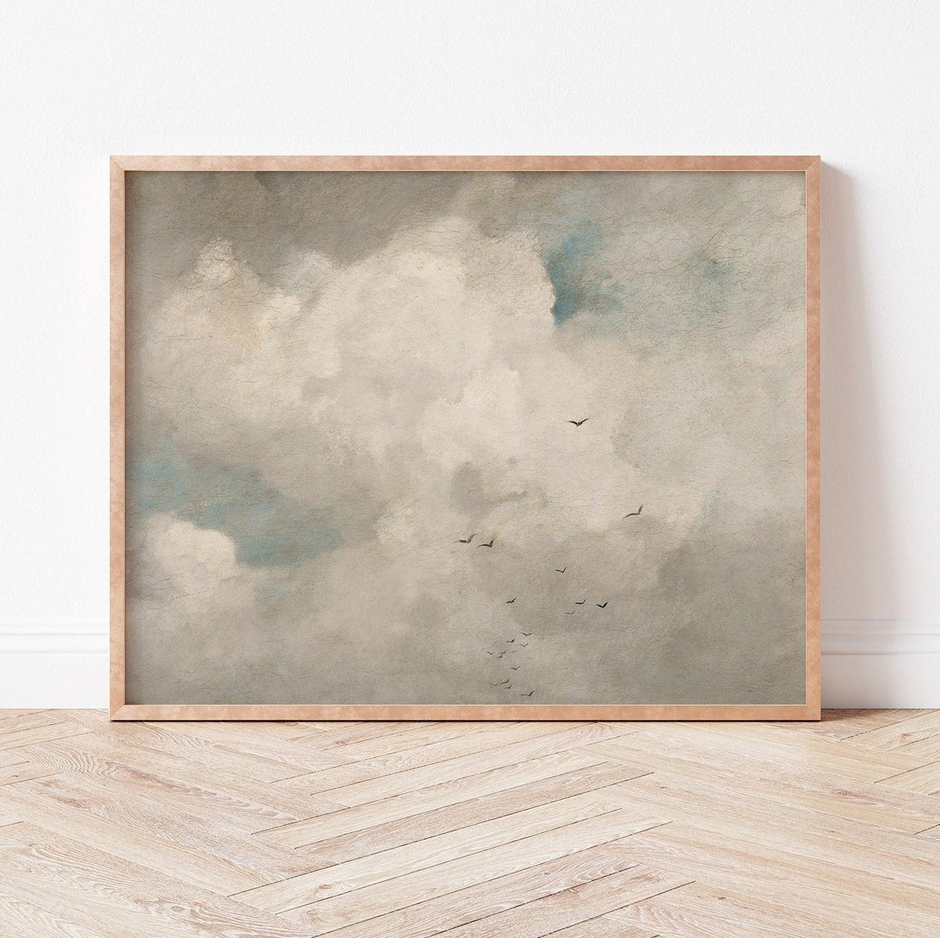 Framed fine art print of a cloud scene on a wooden floor with a white wall background